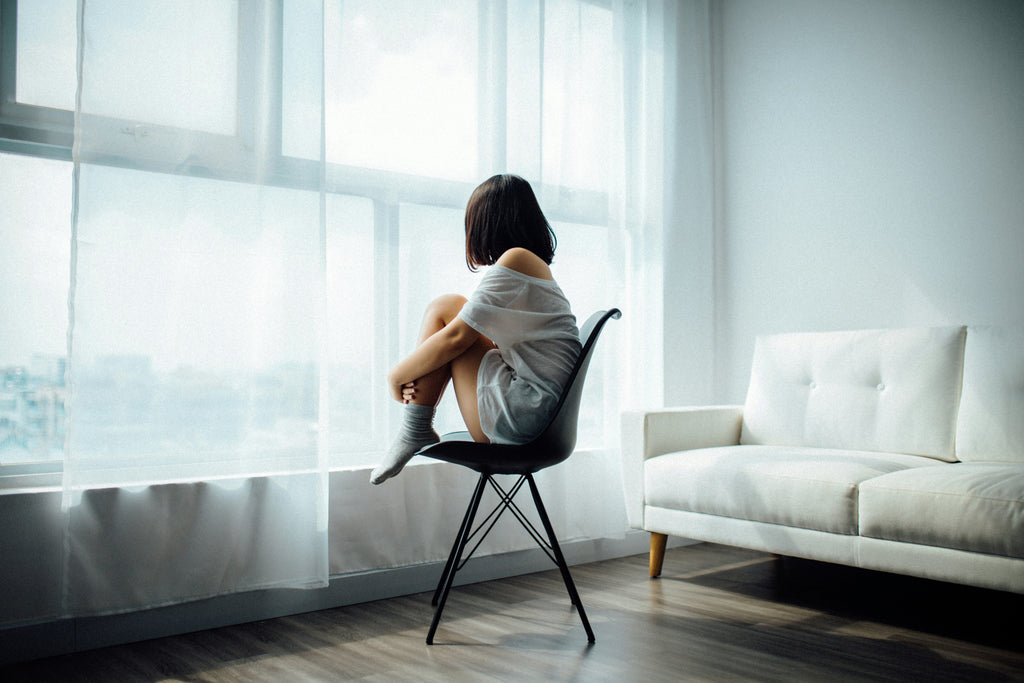 Girl looking out a window on a chair