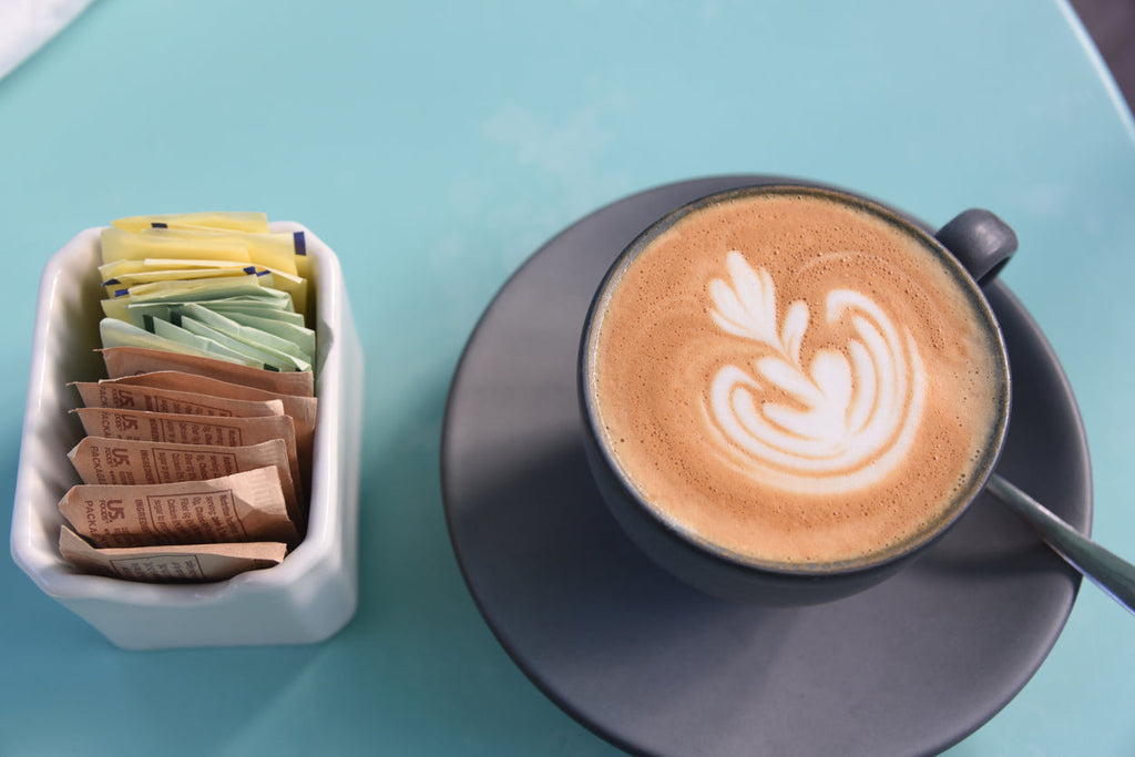 coffee with packs of artificial sweeteners